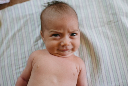 A newborn baby making hysterical expressions and trying to understand something